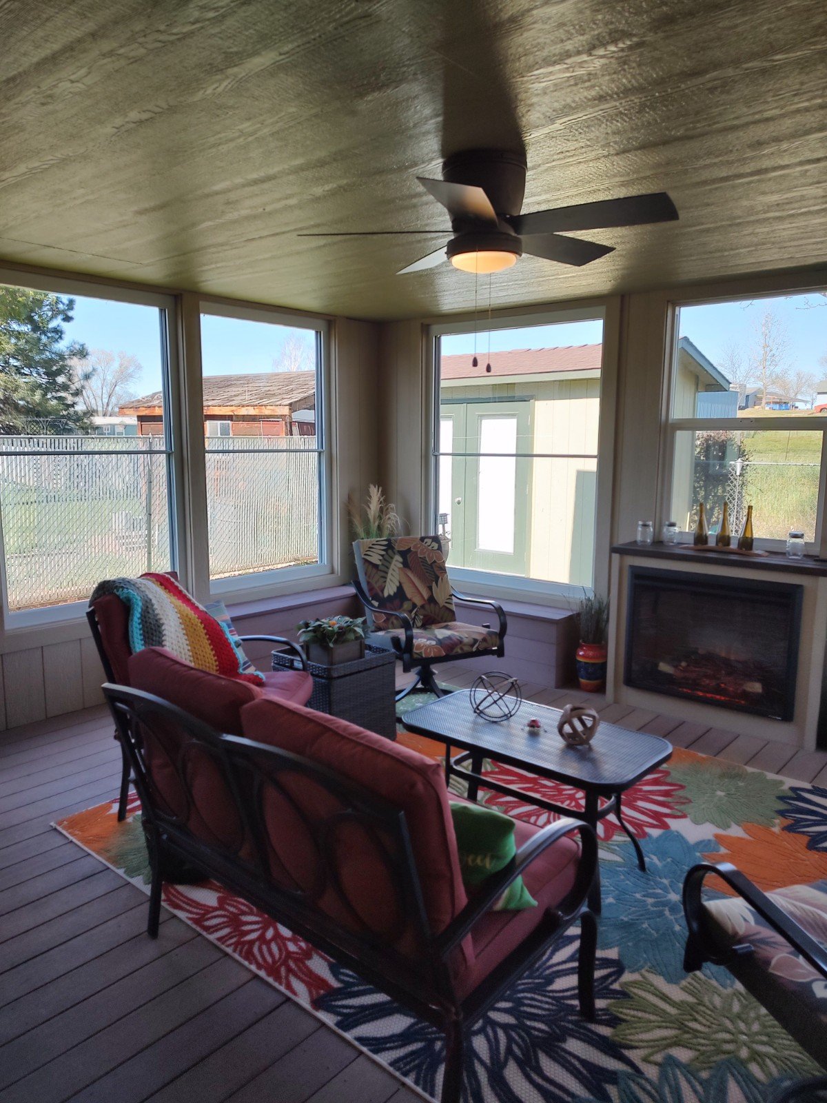Enclosed porch interior with windows and ceiling fan