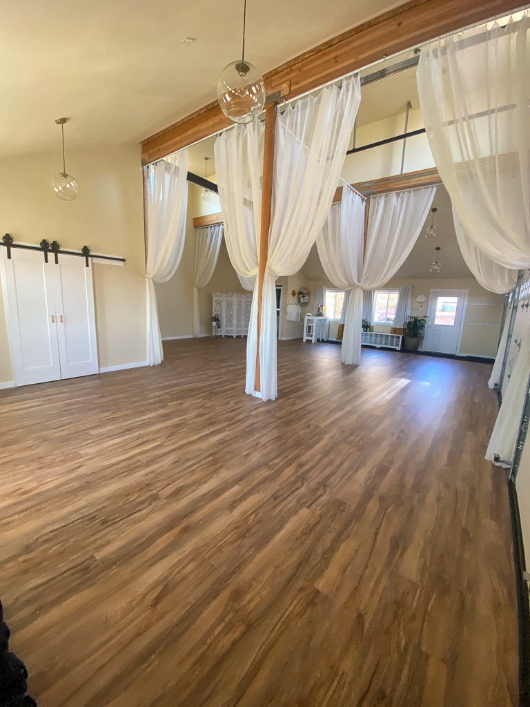 Yoga studio interior with wood floor and hanging curtains