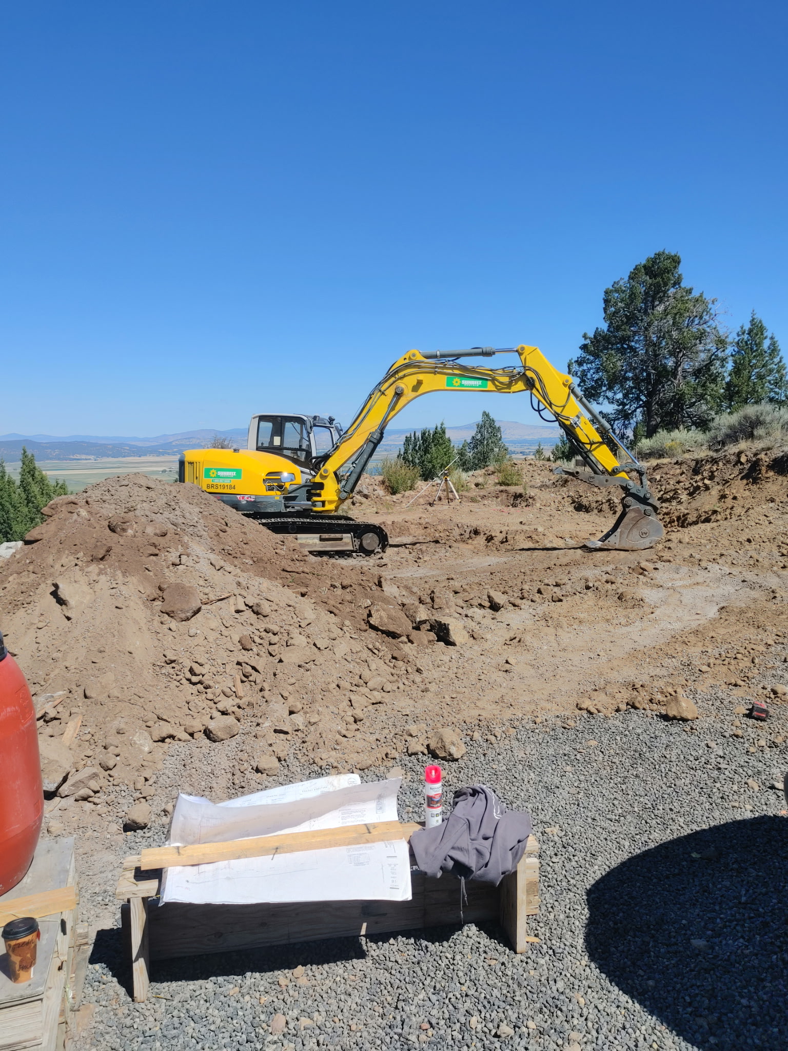 Excavator performing earthwork on a Southern Oregon site