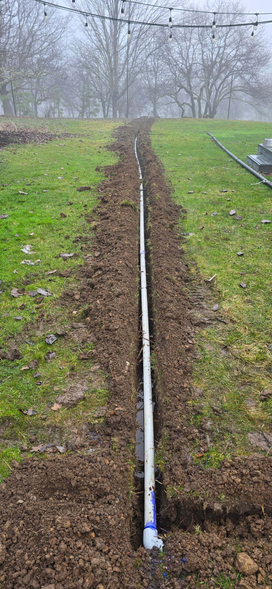 Exposed septic service line in a prepared trench