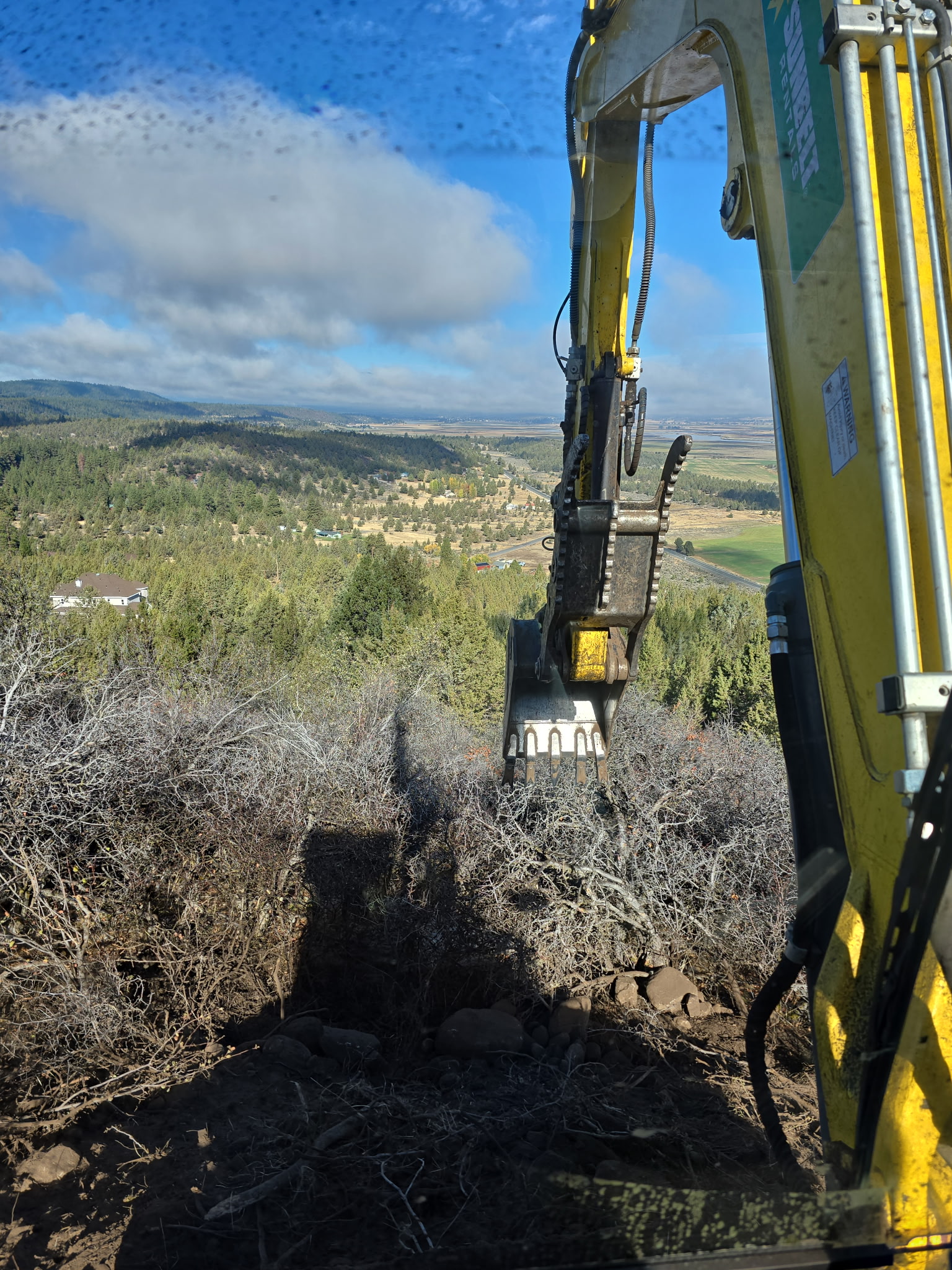 Excavator working in open Southern Oregon terrain